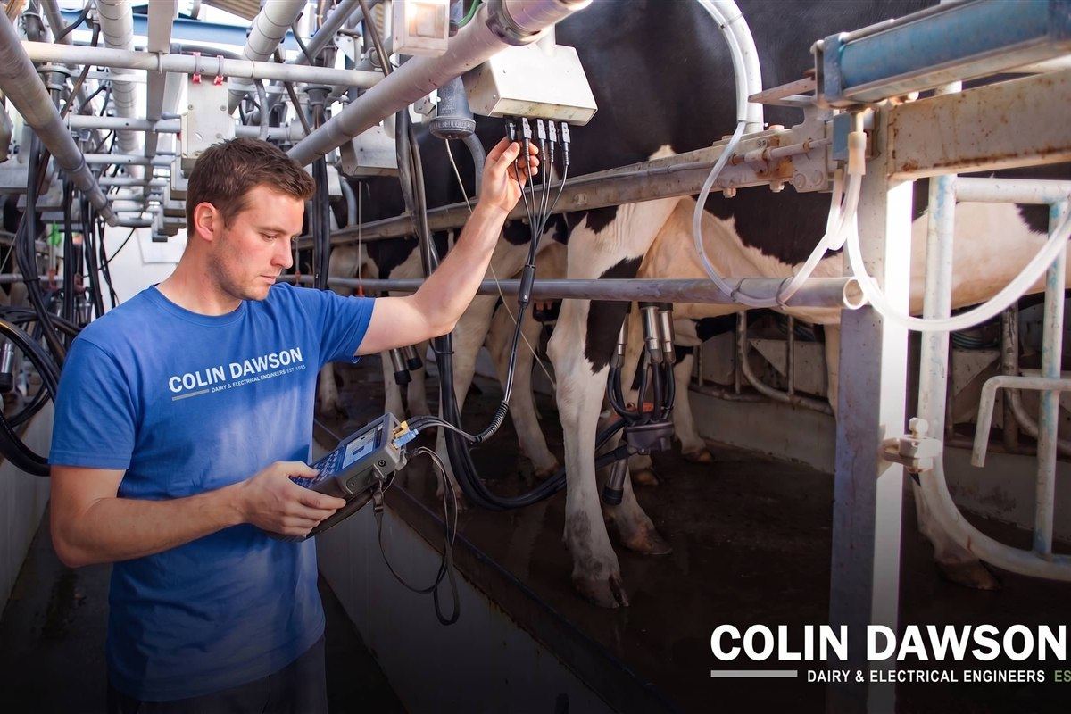 Colin Dawson Ltd engineer testing milking-point wiring with a handheld instrument